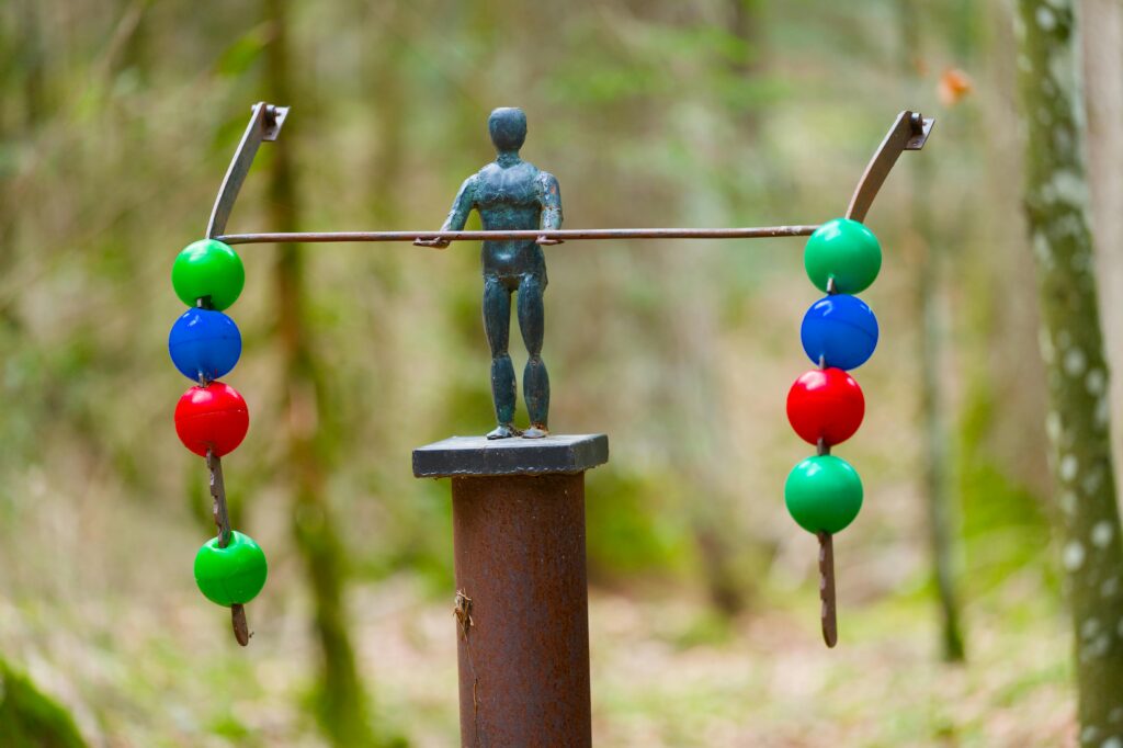 Sculpture blending man and nature in a Swiss forest, colorful and artistic.